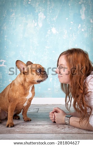 studio shot of beautiful young woman with her pet little dog french bulldog