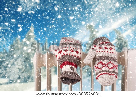 gloves on a radiator / heater on a blue cold winter landscape