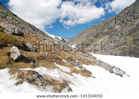 Mountain Landscape with Melting Snow, Blue Sky and Clouds. Tundra of Lovozerie, Russia