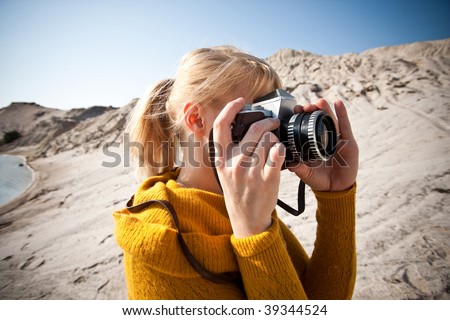woman with a old camera taking photos in the desert