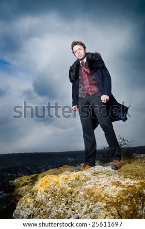 Stylish man over dramatic sky background
