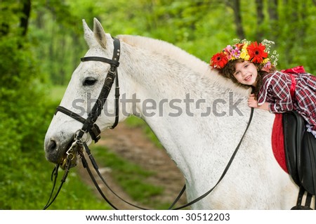 Little girl riding horse in the forest