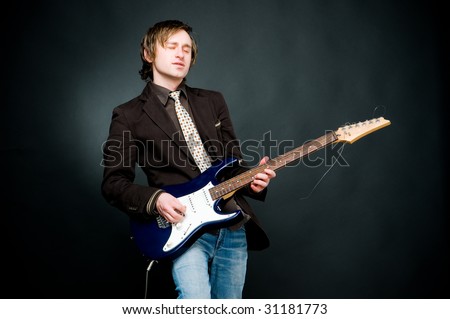 Man playing electro guitar, studio shot