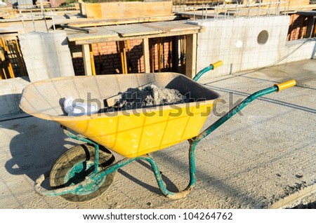 Yellow wheelbarrow in construction in progress