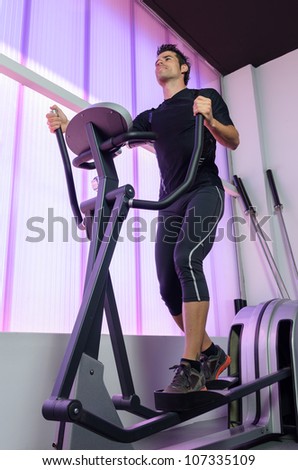 Athlete in gym elliptical machine. Man training hearth with cardio exercising in treadmill. Sportsman working out.