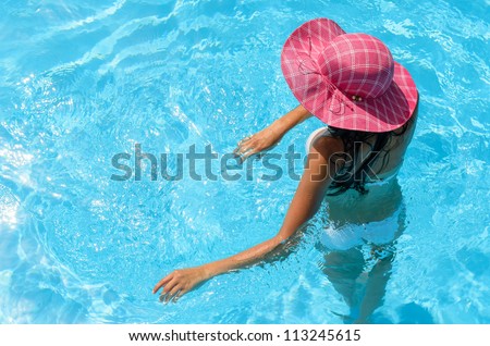 Relaxing woman in pool on summer holiday.  Caucasian woman relaxing into water, Copy space.
