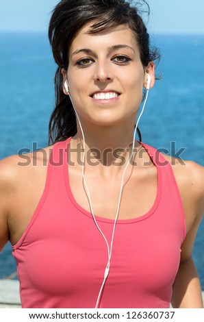 Woman running portrait on sea background. Beautiful fitness caucasian girl jogging on summer