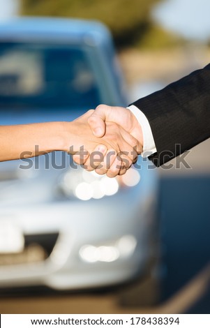 Car sales. Two people shaking hands after commercial business agreement.