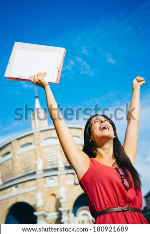 Female college student success. Young blissful woman raising arms at college outdoor. Successful happy girl.