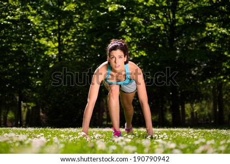 Fitness woman ready for running outdoor in city park. Female runner training outside on spring.