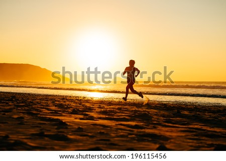 Female athlete running on beautiful sunset or morning at beach. Runner on summer workout.
