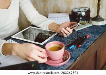 Working at home concept. Entrepreneur business woman checking email or messaging on smartphone and drinking coffee.