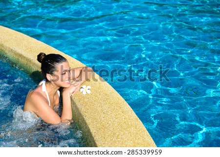 Beautiful happy woman enjoying relax in spa at resort pool. Relaxing outdoor jacuzzi.