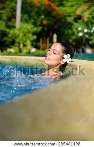 Beautiful woman enjoying relax in spa pool at resort. Beauty and body care concept.