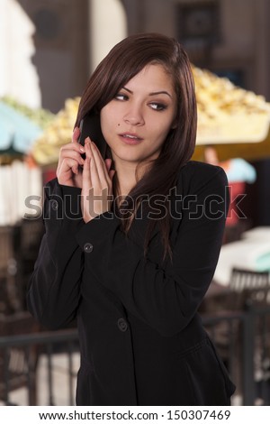 Beautiful business woman does not want the person she\'s talking to on the phone to hear something.