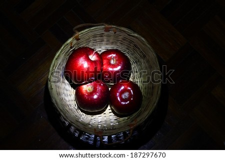 Red apples in basket in low light