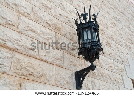 A classical design vintage decorative wrought iron lamp on a brick wall