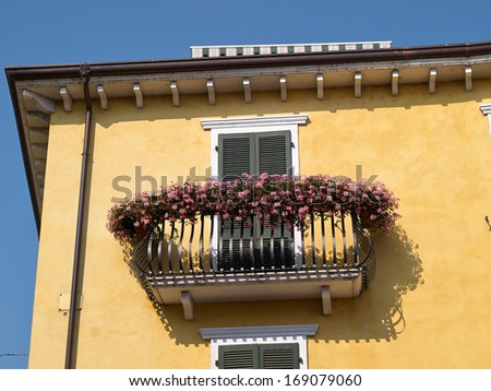 Typical classical Italian house balcony with blooming flowers in Lake Garda Verona area