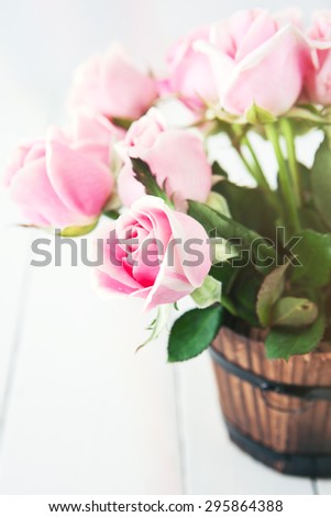 pink roses in small wooden bucket with color effect