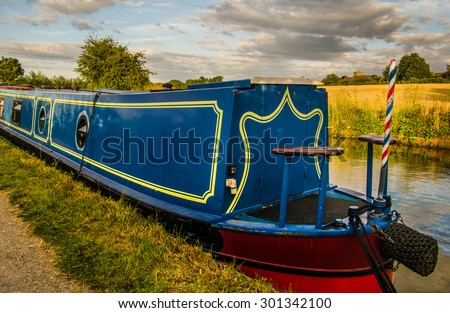 Blue Narrow Boat - Warwickshire, the heart of England. Narrowboat moored on a stretch of the Grand Union Canal by the town of Radford Semele near Leamington Spa, Warwickshire.