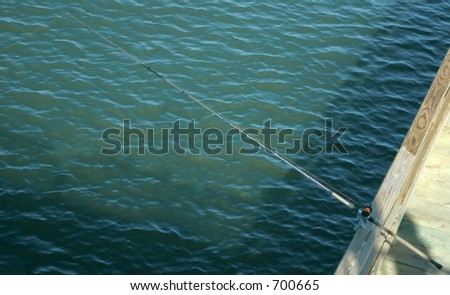A fishing pole on a fishing pier.