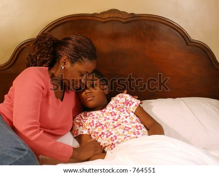 A mother comforts her sick daughter.