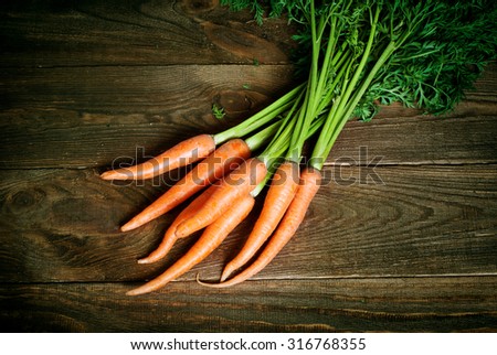 Some fresh carrots at the wooden table