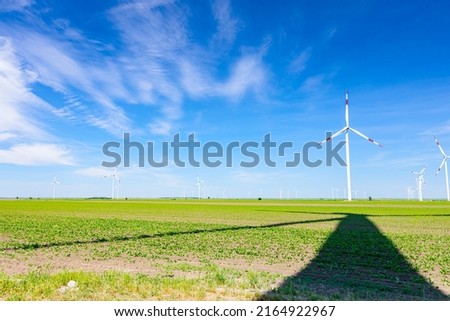 Similar – Image, Stock Photo Long shadow under windmill, large wind power turbines spinning to generating clean, green, renewable energy