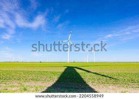 Image, Stock Photo Long shadow under windmill, large wind power turbines spinning to generating clean, green, renewable energy