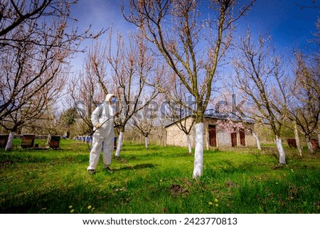 Similar – Foto Bild Landwirt in Schutzkleidung mäht Rasen in einem Garten mit einem Benzinrasenmäher