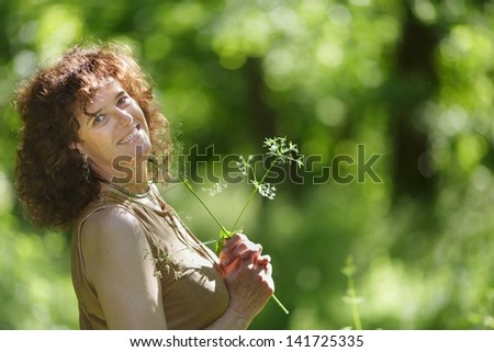 Middle aged mature woman enjoying nature under spring sunlight