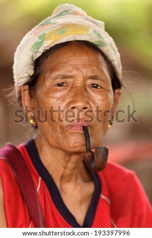 UMPHANG, THAILAND, NOVEMBER 30 : close portrait of a Karen tribe woman, Thai ethnicity, smoking tobacco pipe, near the village of  Umphang, north Thailand on November 30, 2012