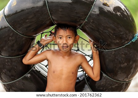 BUKIT LAWANG,INDONESIA, July 06 : Unidentified little boy holding a air tube for tubing in the river in the Bukit Lawang village, Sumatra, Indonesia, on July 06, 2010