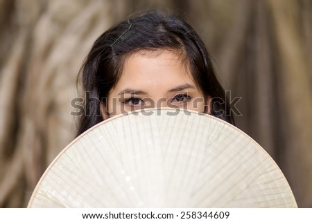 Close up Mysterious Young Woman Covering her Half Face with conical hat While Looking at the Camera.