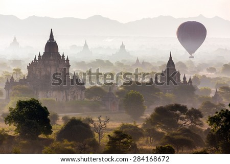Air balloons flying over pagodas at misty dawn in the plain of Bagan, Myanmar (Burma)