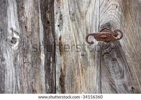 detail on old rotten door with rusty handle, focus on right