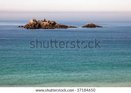 little island rock on tranquil blue ocean, brittany, france
