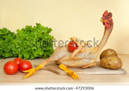 full length chicken lying on cutting board with vegetables in kitchen