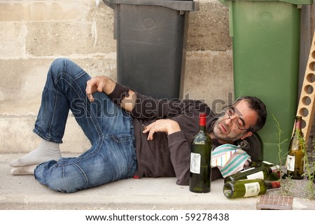 Poor And Drunk Man Lying On Sidewalk With Bottles Of Wine Near Trash ...