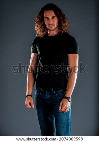 Similar – Image, Stock Photo Long haired young handsome man on a black background with a light illuminating his face, with a flirtatious expression for the camera showing a slight smile