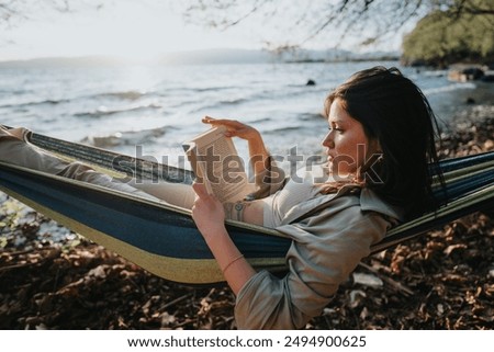 Image, Stock Photo Reading girl deeply absorbed in a book, stretching her feet from a colorful striped hammock