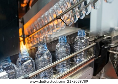 The abstract scene of plastic processing of PET bottles in the drinking water factory. The hi-technology of plastic bottle manufacturing process. Сток-фото © 