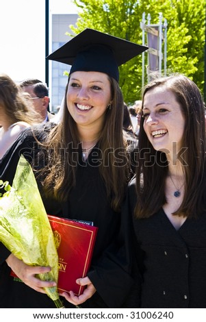 College graduates smile after receiving their degrees