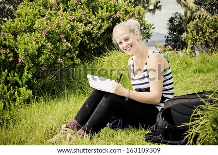 Young woman writing in her diary during her travels