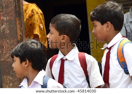 CALCUTTA, INDIA - JUNE 15: Group of young boys wait for school-bus June 15, 2008 in Calcutta, India. The boys are dressed in the traditional school uniform.