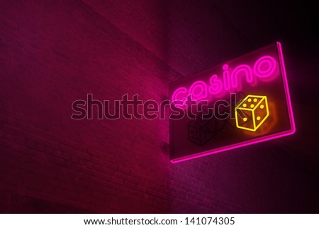 Casino neon sign on brick wall.