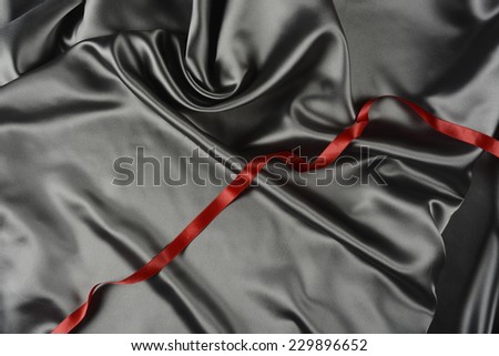 Effects of light in one gray satin fabric and red ribbon