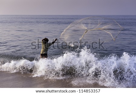KANNUR - DECEMBER 27: an unidentified fisherment casts his small net into the Arabian Sea on December 27,2011 at Thottada Beach, Thottada village, Kannur, Kerala, India.