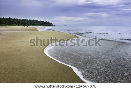 Kannur, Kerala, India. View of Thottada beach at sunset 10 km south of Kannur in Kerala, south India. It is a calm evening on the Malabar Coast and the tide is receding.