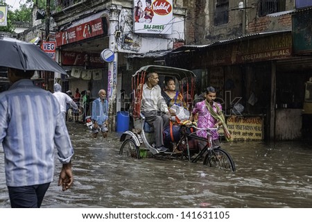 VARANASI, INDIA - AUGUST 11: a cycle rickshaw with passengers tries to negotiate a flash flood and heavy monsoon rain on August 11, 2011 in Varanasi, Uttar Pradesh, India.